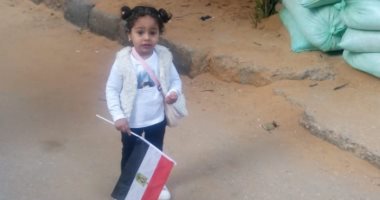 طفلة تشارك والديها فى الاستفتاء على التعديلات الدستورية بالأعلام بالجيزة