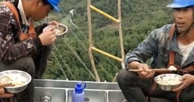 بأحزمة الأمان.. عمال كهرباء صينيون يناولون الطعام على ارتفاع 130 مترا..صور 