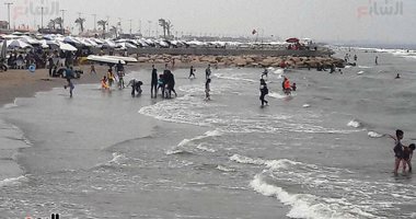 صور.. شواطئ بورسعيد تجذب مئات المصطافين هربا من الحر