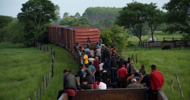 المهاجرون يتسلقون قطار شحن فى المكسيك للوصول للحدود الأمريكية