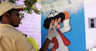 فيديو وصور.. "عيد" رسام السعادة بالفيوم.. طالب يجوب القرى لرسم الواجهات