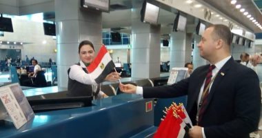 مطار القاهرة يحتفل بذكرى نصر أكتوبر بتوزيع علم مصر على الركاب.. صور 
