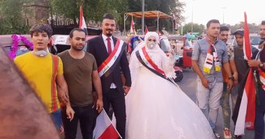 شاهد.. زفة عروسين عراقيين بتوك توك وسط المتظاهرين فى بغداد