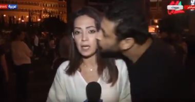 بوسة على الهواء.. متظاهر يقبل مراسلة تلفزيونية خلال نقل احتجاجات لبنان