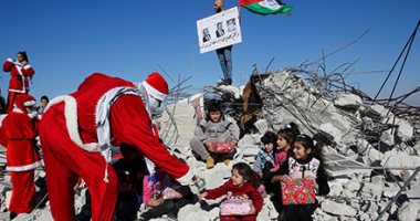 صور.. فلسطينيون بزى بابا نويل فوق أنقاض منازل هدمها الإحتلال الإسرائيلى 