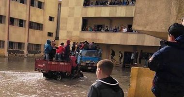 صور.. طلاب بالإسكندرية يدخلون اللجان بسيارات النقل لتراكم مياه الأمطار