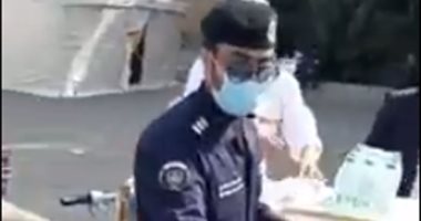 فيديو.. شرطى كويتى يوزع المياه على العمالة المصرية أثناء فحصهم بمركز طبى