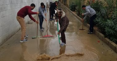 أبطال لقمة العيش.. عمال مصانع بدر يرفعون مياه الأمطار لإنقاذ المنشآت.. صور