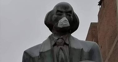 تمثال الكاتب الجالس فى أسيوط بـ"الكمامة" يثير الجدل..وآخرون: لتوعية المواطنين