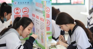 مدرسة صينية تفصل بين الطلاب بحائط كرتوني أثناء الطعام لمنع عدوى كورونا