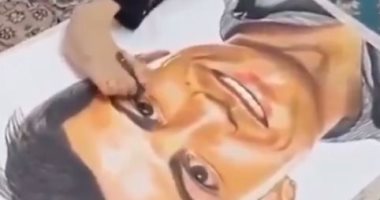 فتاة معاقة تبدع فى رسم صورة لوجه رونالدو بقدمها.. فيديو