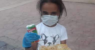 "لميس" أصغر طفلة متطوعة فى مبادرة "إفطار صائم" وهى ترتدى الكمامة بالأقصر