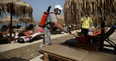 اليونانيون يعودون للشواطئ وسط موجة حارة مع مسافات بين المظلات خوفا من كورونا
