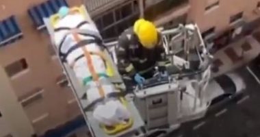 رجل إطفاء ينقل عجوزا فى التسعين مصابا بكورونا برافعة إنقاذ من منزله.. فيديو