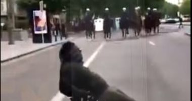 أعصابه فى تلاجة.. متظاهر يجلس على كرسى وسط احتجاجات بلجيكا ويتحدى الشرطة