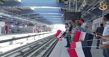 مواطنون يلوحون بالأعلام من أرصفة محطة مترو عدلى منصور 