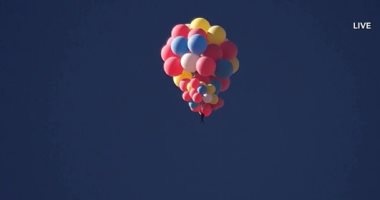 الساحر الطائر.. مغامر يصعد للسماء بـ 52 بالونا على طريقة "البالون الأحمر".. ألبوم صور