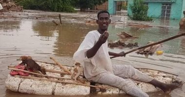 سودانى ينقذ كلاب صغيرة من الغرق فى مياه الفيضانات.. صور