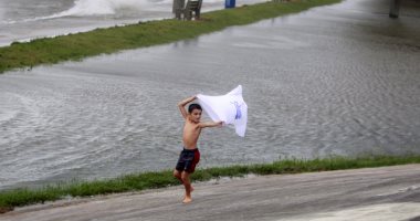 صور.. أمريكيون يلهون وسط مياه إعصار "سالى" فى الساحل الغربي للبلاد