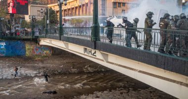 مطاردة بين الأمن والمحتجين تنتهى بسقوط شاب فى أحد أنهار تشيلي.. فيديو وصور