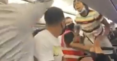 امرأة تتعرض للصعق بسبب عدم ارتداءها كمامة على الطائرة .. فيديو