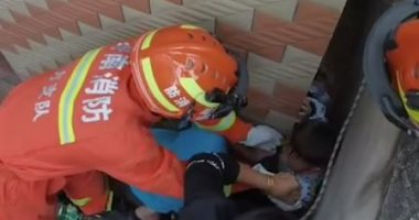 فرق الإنقاذ تتدخل.. طفل يسقط بين جدارين أثناء لعبه مع كلب فى الصين.. فيديو وصور