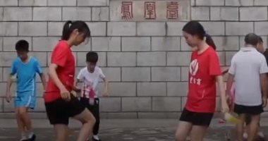 شباب يمارسون "لعبة الريشة"ويستعرضون المهارة وخفة الحركة بحديقة صينية..فيديو