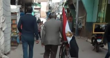 ناخب يرفع علم مصر على دراجته لحث المواطنين على المشاركة بالتصويت فى دمياط