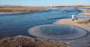 تدفق المياه يصنع قرصا دائريا من الجليد بظاهرة غريبة فى نهر صينى.. فيديو