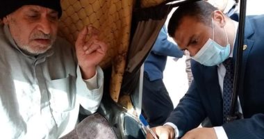 رئيس لجنة انتخابية يخرج لمساعدة مواطن مسن للإدلاء بصوته فى المحلة