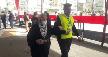 الشرطة تساعد مسنة للإدلاء بصوتها فى جولة الإعادة لانتخابات النواب ببورسعيد  