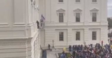 متظاهرون ينزلون العلم الأمريكى من فوق مقر الكونجرس.. فيديو وصور