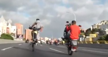 سائق دراجات يقدم حركات بهلوانية بدراجة نارية فى شوارع فنزويلا.. فيديو