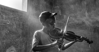 100 صورة عالمية.. "لحن الأمل" طفل يعزف وسط الحروب 