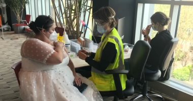 بعد إلغاء حفل زفافها بسبب كورونا.. أمريكية تتلقى اللقاح بفستان الزفاف.. صور