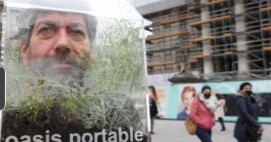 فنان بلجيكي يضع رأسه داخل فقاعة زجاجية للوقاية من كورونا فى الشارع.. فيديو
