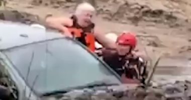 رجال طوارئ ينقذون عجوزا علق داخل سيارته وسط سيول أريزونا.. فيديو