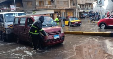 رجال المرور بالإسكندرية يساعدون قائدى السيارات فى الخروج من مياه الأمطار.. صور