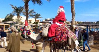 سائح بلجيكى يرتدى ملابس بابا نويل يوزع الهدايا على السياح بالغردقة.. لايف وصور
