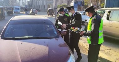 صور.. رجال الشرطة يوزعون الورود على المواطنين وقائدى السيارات بالغربية