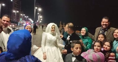 عريس وعروس يتحديان الأمطار على كورنيش بنى سويف.. فيديو وصور