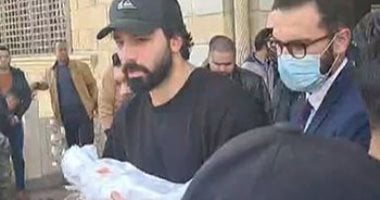 الفنان حازم إيهاب يحمل طفله الرضيع بالكفن بعد صلاة الجنازة 