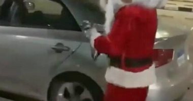 احتفالات رأس السنة.. شاب يرتدى ملابس "بابا نويل" لمسح السيارات ببورسعيد.. صور
