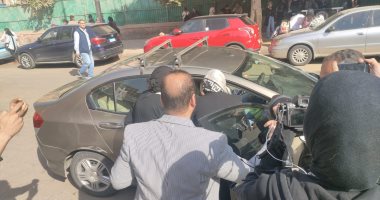 قاضية تتوجه ببطاقة التصويت لناخب من كبار السن داخل سيارته بمصر الجديدة