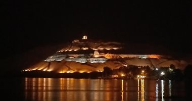مشهد ساحر.. إضاءة جبل أبو الهوا فى مدينة أسوان أمام النيل.. فيديو