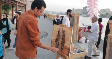 "كريم" فنان يبدع فى رسم لوحات الهوية المصرية على ممشى المنصورة.. صور