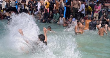 الباكستانيون يهربون من ارتفاع درجات الحرارة إلى السباحة والقفز فى الماء