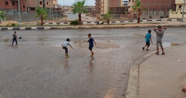 فرحة وتنطيط.. أطفال يلعبون بمياه المطر بعد تساقطه بغزارة فى أسوان.. فيديو