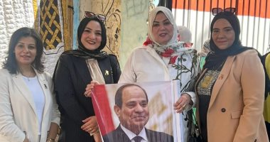 سيدات سوهاج يحملن صورة الرئيس أثناء المشاركة فى انتخابات مجلس الشيوخ