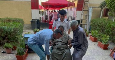 الشرطة تساعد قعيد على الوصول إلى لجنته الانتخابية بالتجمع الخامس.. صور